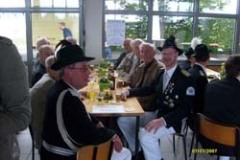 Mehrere Personen in einer Schießsportgruppe, die mit Luftgewehren auf Zielscheiben schießen.